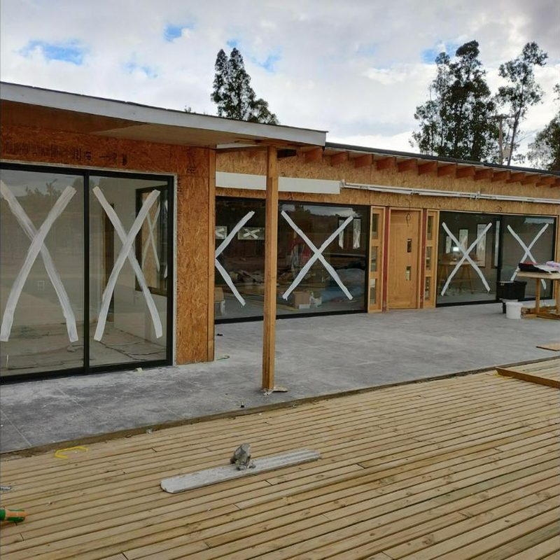 Ventanales de aluminio negro recién instalados en una casa en construcción